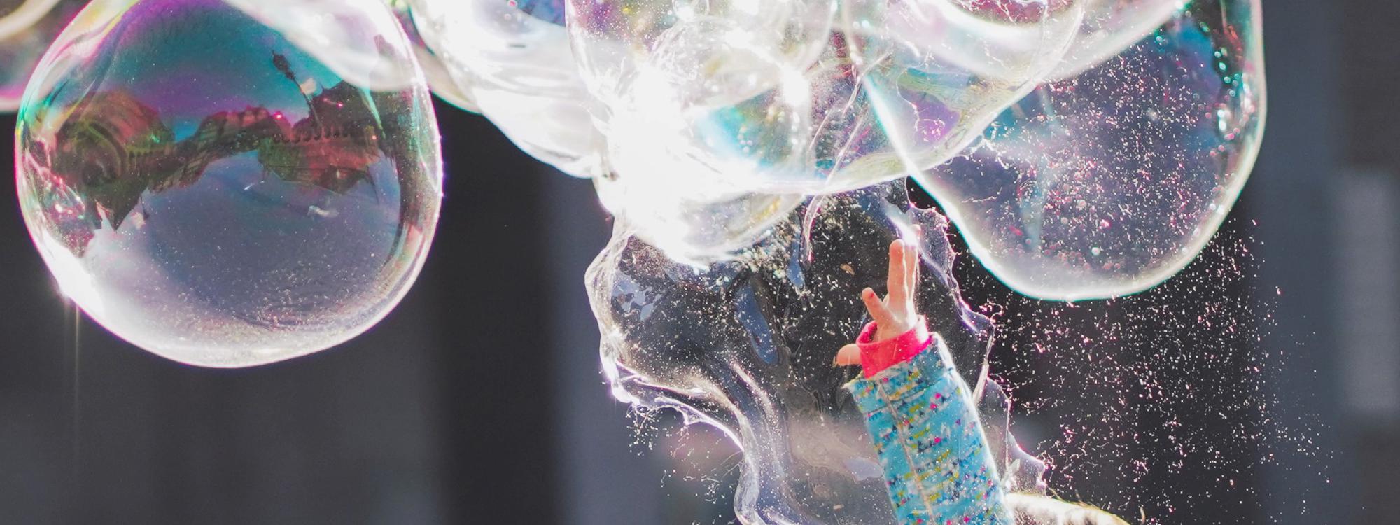 Kind hüpft nach großen Seifenblasen