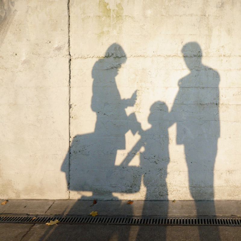 Schattenbild einer Familie an Wand - Family First