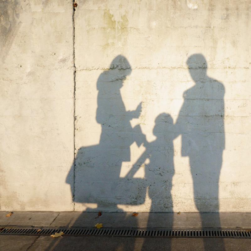 Schattenbild einer Familie an Wand - Family First